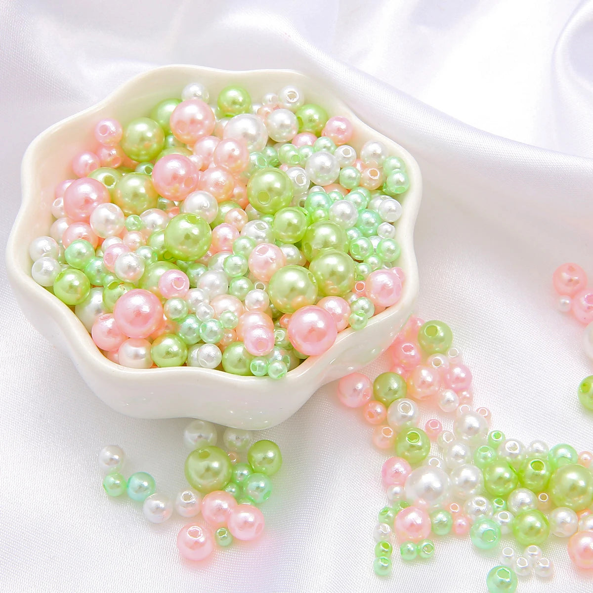 A bowl filled with assorted pink and green pearl beads for jewelry making