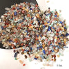 A pile of natural mixed quartz crystal stones in various colors including clear, blue, pink, and amber.