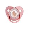 A rose gold crystal bling pacifier for newborns with a silicone nipple and decorative surrounding.