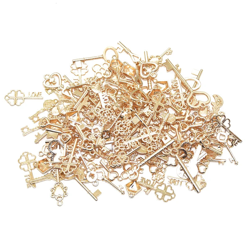 A pile of vintage gold-toned metal key charms for DIY jewelry making