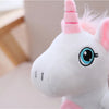 A white unicorn plush toy with pink accents and a spiraled horn is shown in a close-up view.
