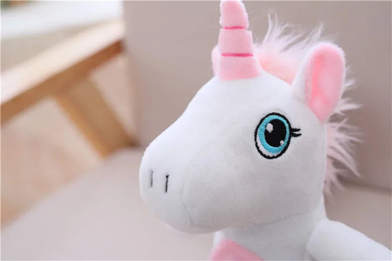 A white unicorn plush toy with pink accents and a spiraled horn is shown in a close-up view.