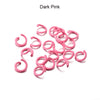 A pile of pink metal open jump rings for DIY jewelry making