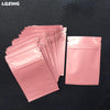 A stack of pink mini reusable ziplock bags with secure zippers is displayed on a dark surface.