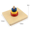 Wooden sensory toy set with stacked colored rings and a wooden dowel on a light wood board.