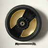 A black circular product with a yellow rim and a central mechanism, accompanied by a small metal rod.