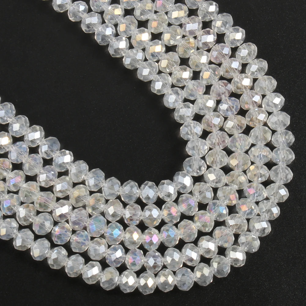 A close-up view of clear faceted crystal glass beads arranged in a curved line for jewelry making