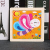 A wooden tangram puzzle featuring a pink and purple animal design on an orange background.
