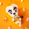 A pile of white and black building blocks resembling a skull is placed on an orange surface.