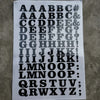 A sheet of DIY iron-on heat transfer patches showing various uppercase and lowercase letters and symbols.