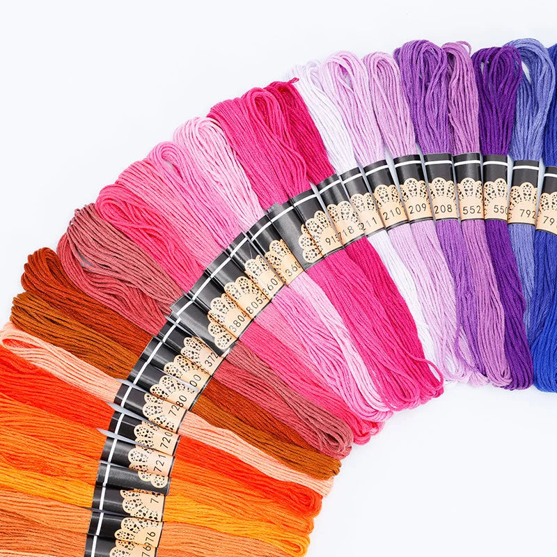A collection of multicolored embroidery thread skeins in various shades of pink, purple, orange, and blue.
