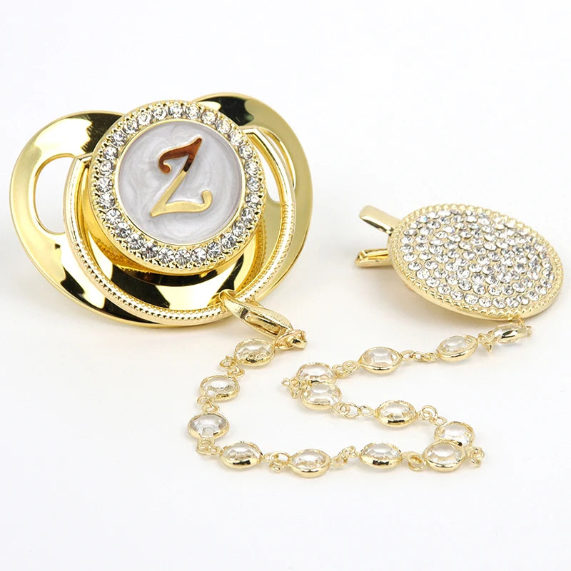 Gold and clear rhinestone pacifier featuring a Z initial on a silicone disc with a clip.