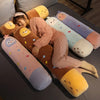 A collection of long body stuffed animal plush pillows in various pastel colors and textures.