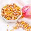 A pile of assorted golden and pinkish pearl beads for jewelry making
