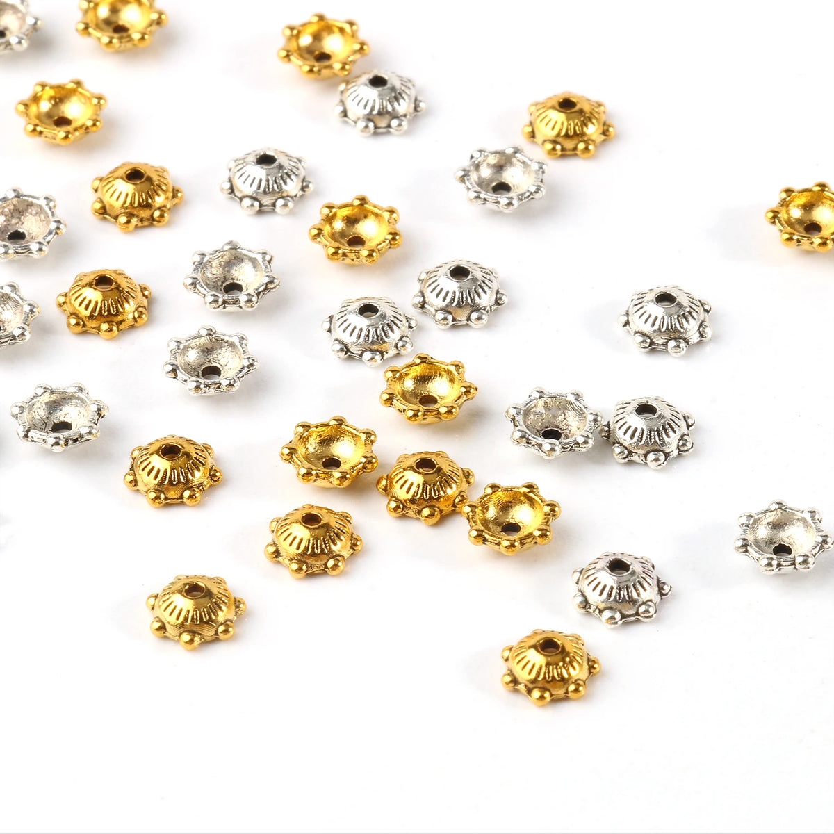 A collection of small, gold and silver Tibetan style hollow flower bead caps for jewelry making.