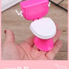 Pink miniature copper soup pot for dollhouse kitchen displayed in a hand.