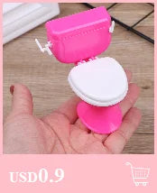 Pink miniature copper soup pot for dollhouse kitchen displayed in a hand.