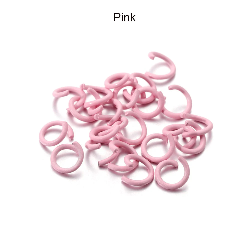 A pile of pink metal open jump rings for DIY jewelry making