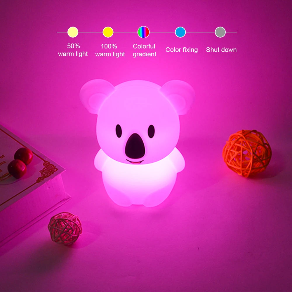 A white koala-shaped LED night light glows pink on a surface, with a color gradient indicator bar above it.