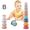 A baby is shown next to a set of stacked, boat-shaped plastic cups in various pastel colors.
