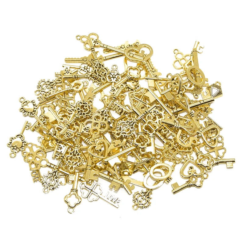 A pile of vintage gold-colored metal key charms for DIY jewelry making