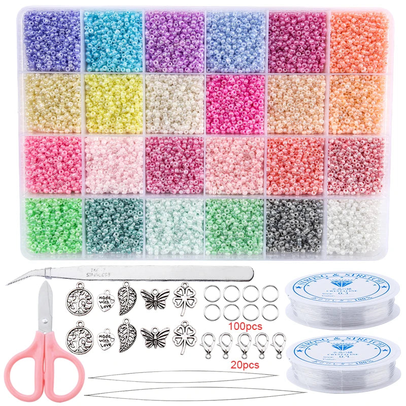 A variety of colored glass seed beads in various shades are displayed in a clear plastic container with a pair of pliers and 