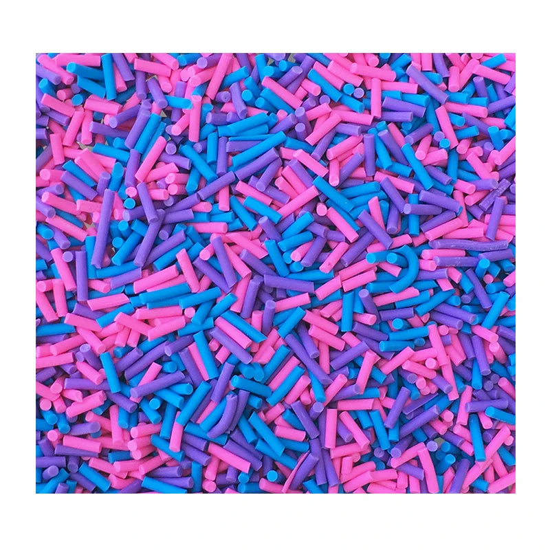 A close-up view of brightly colored soft polymer clay candy sprinkles in various shades of pink, blue, and purple.