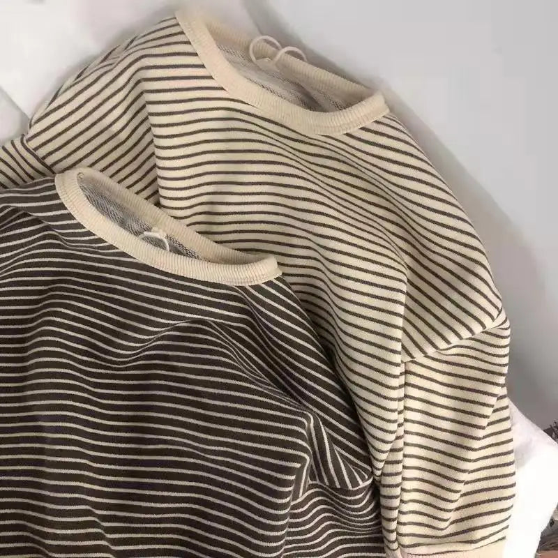 A close-up of a beige and brown striped kids cotton pullover sweatshirt.