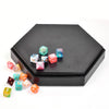A black hexagonal storage box containing various colored dice and a small velvet interior.