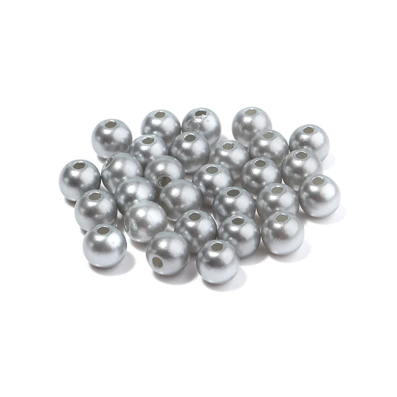 A pile of small, silver-colored imitation pearl beads for DIY jewelry making.