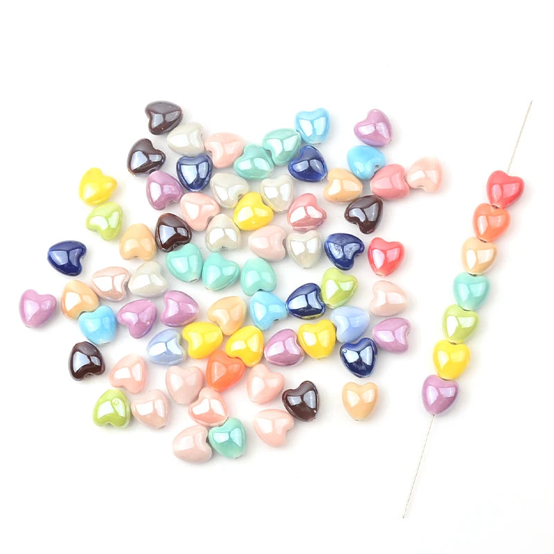 A collection of multicolor heart-shaped acrylic beads in various shades of pink, blue, and green.