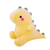 A yellow dinosaur plush toy with green spikes and a pink nose.