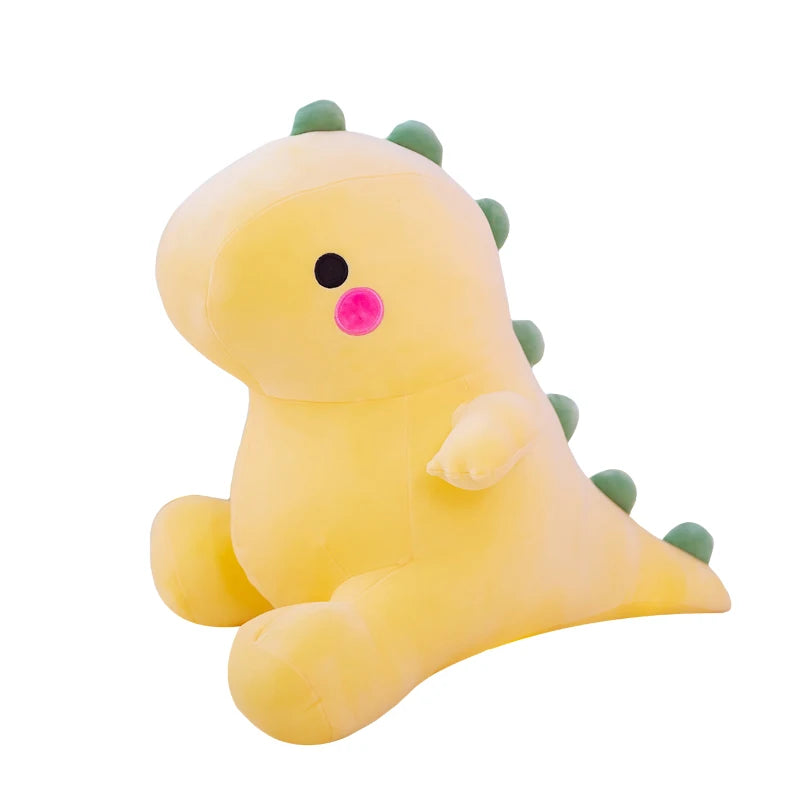 A yellow dinosaur plush toy with green spikes and a pink nose.