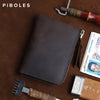 A dark brown leather coin purse with a zipper is shown on a brown surface next to a knife and a tool.