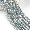 A close-up of a strand of iridescent, faceted crystal glass beads for jewelry making.