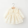 A cream-colored lace princess dress for a toddler girl with a doll collar, displayed on a wooden hanger.
