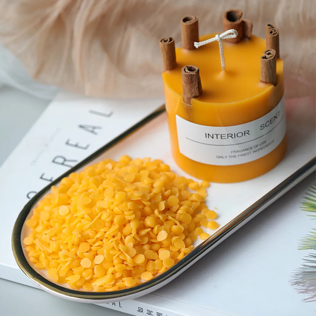 A jar of yellow beeswax next to a pile of yellow cornmeal on a white surface.