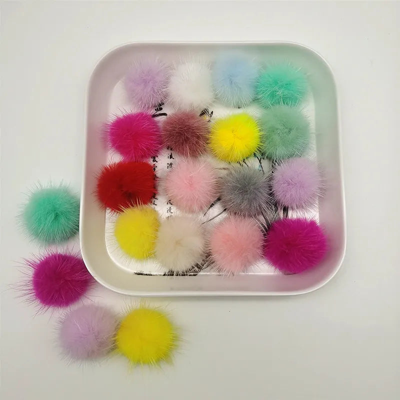 A tray filled with various colored soft DIY mink fur pom poms for crafts and accessories.