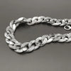 A silver and white marbled acrylic bag chain strap with clips laid out on a dark surface.