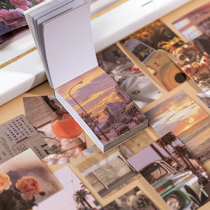 A close-up of an open sticker book featuring various aesthetic landscape designs for scrapbooking and journaling.