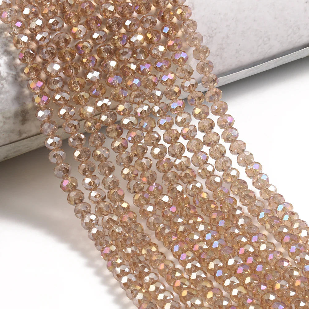 A close-up of numerous faceted crystal glass beads in a warm amber tone, laid out for jewelry making.