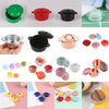 A collection of miniature copper and colored soup pots for a dollhouse kitchen display.