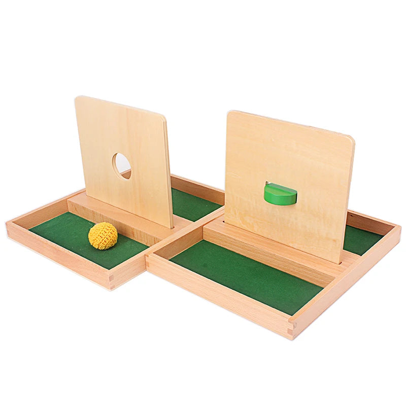 A wooden Montessori sensory toy set featuring two wooden blocks with holes and a green felt mat.