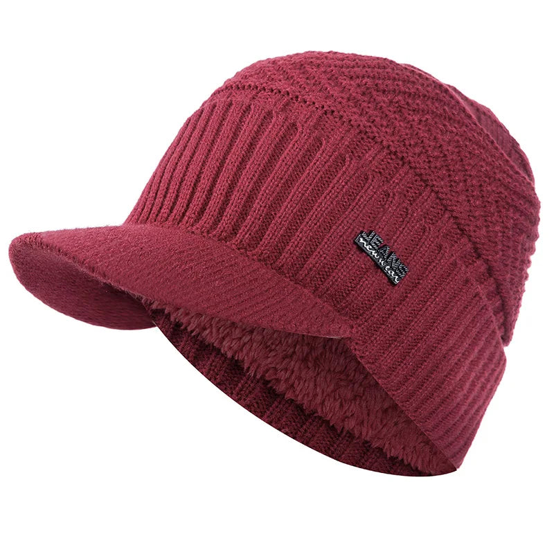 A maroon knit beanie with a brim and fleece lining shown from the side.