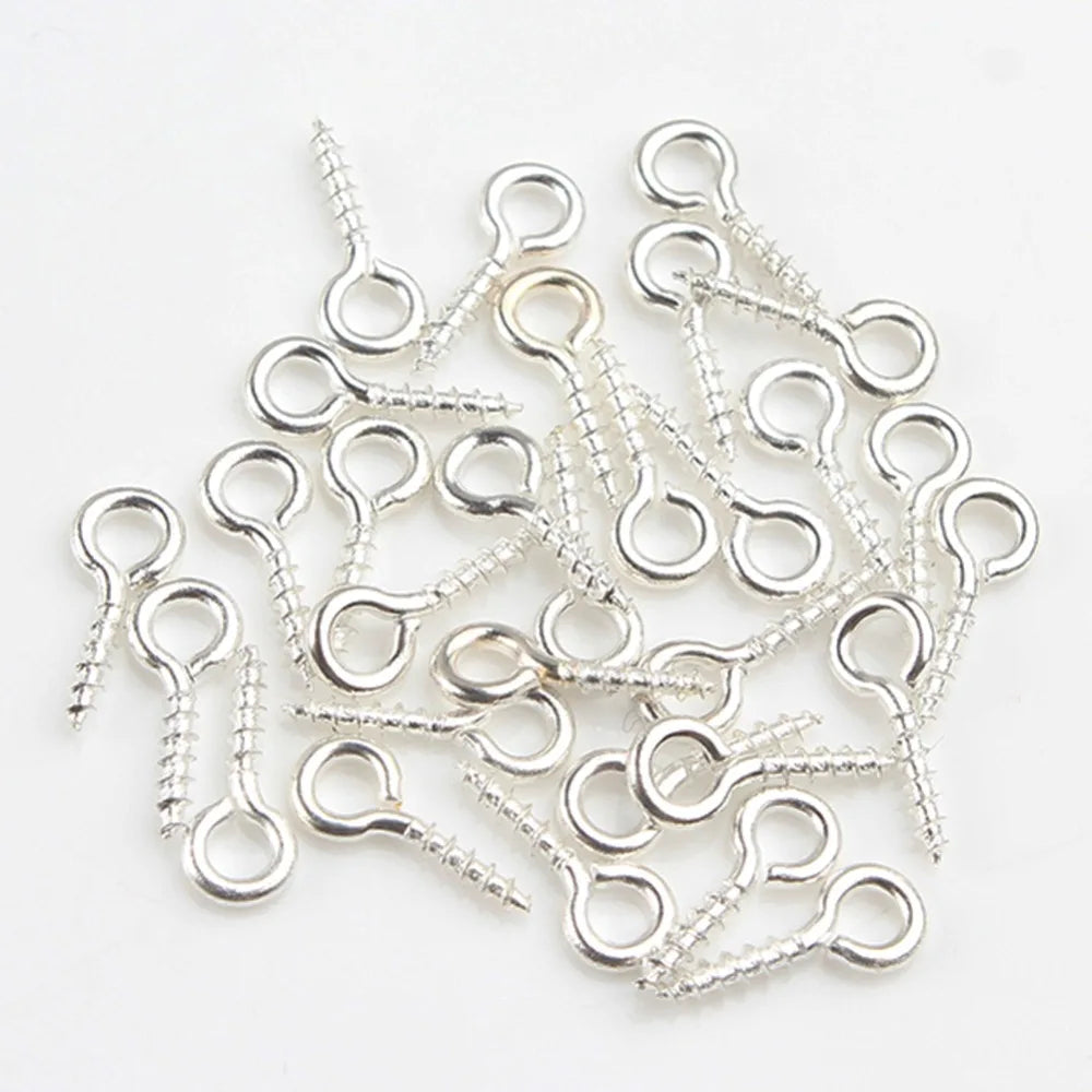 A collection of silver mini eye pins with screw threads for jewelry making