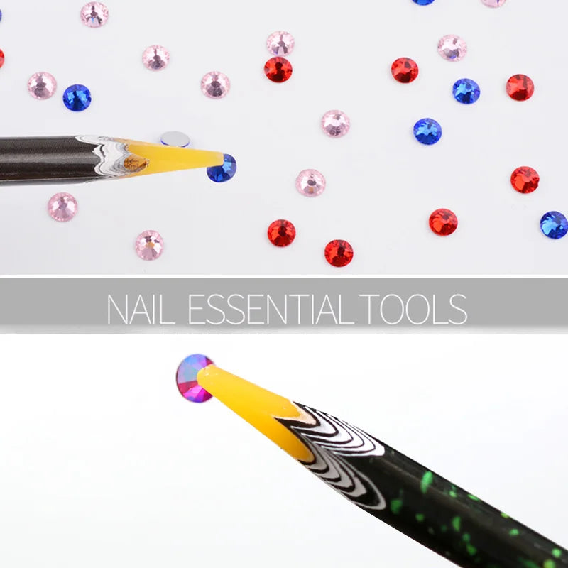 A close-up view of a black pen with a yellow tip, used to pick up nail rhinestones and other embellishments.