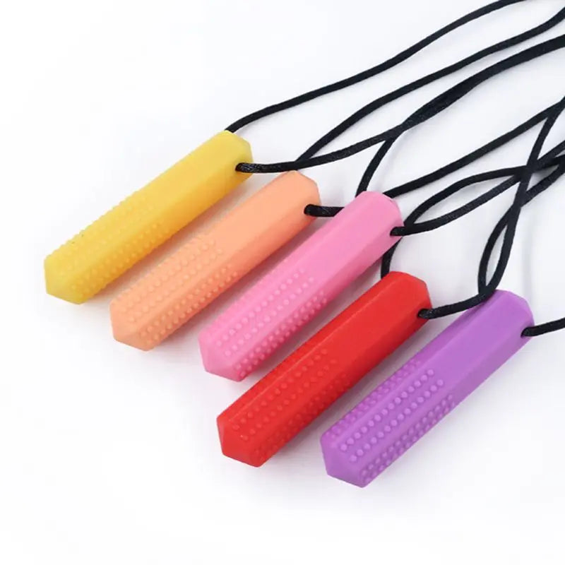 A set of silicone chew necklaces in yellow, orange, pink, and red are displayed against a white background.