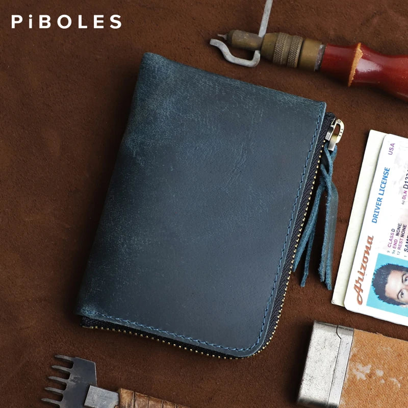 A dark blue leather coin purse with a zipper is shown resting on a brown surface next to a knife and a driver license.