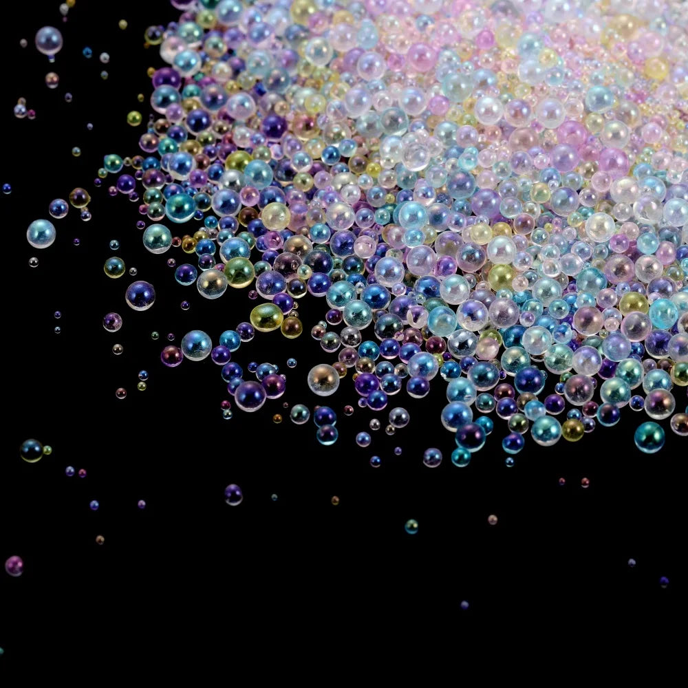 A close-up of iridescent, multi-colored glass bubble beads scattered against a black background.