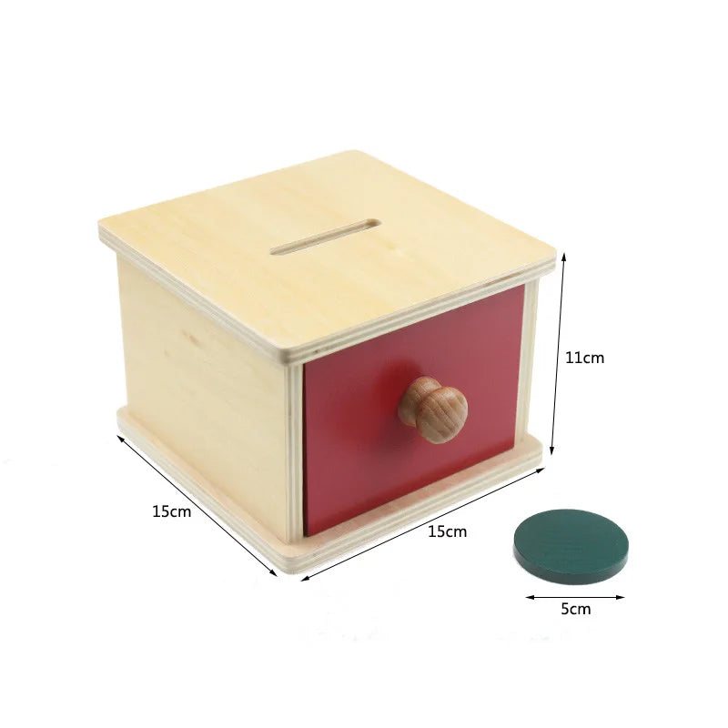 A wooden sensory box toy with a light wood lid and a red base, featuring a wooden knob.